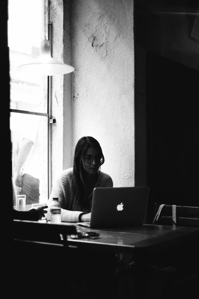 Una persona seduta ad un tavolo con un computer portatile